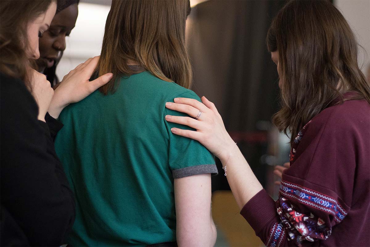 Women in a circle praying and discussing evangelism