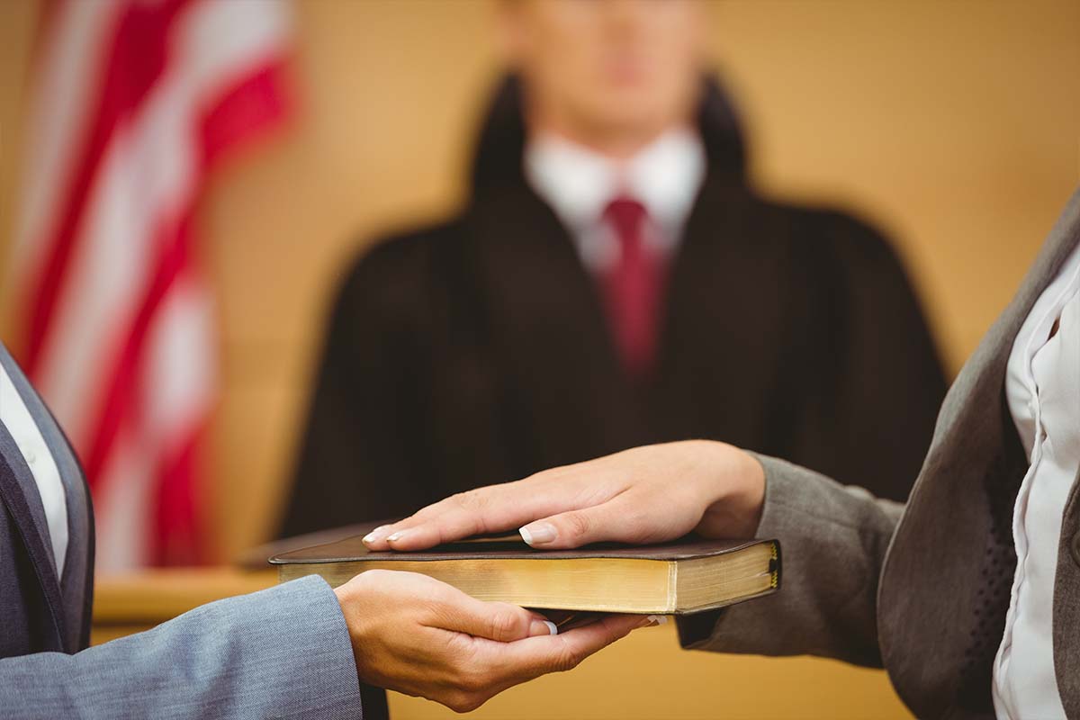 witness at court holding the Bible